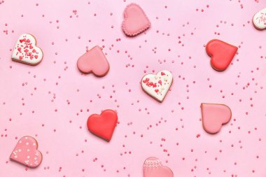 Composition with tasty heart shaped cookies and colorful sprinkles on pink background. Valentine's Day celebration