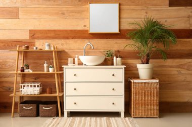 Interior of bathroom with ceramic sink, drawers and shelving unit