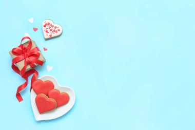 Composition with tasty heart shaped cookies and gift box on color background. Valentine's Day celebration