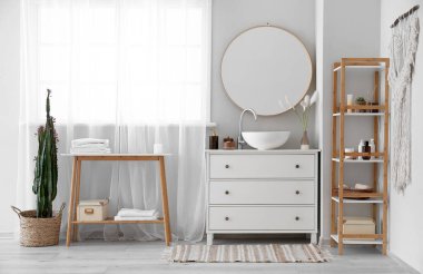 Interior of bathroom with sink on drawer, mirror and bath accessories