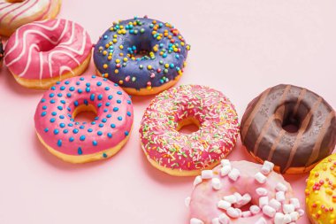Tasty glazed donuts on pink background, closeup