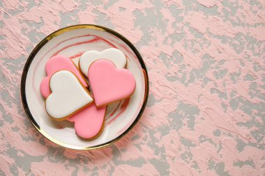 Plate with heart shaped cookies on pink grunge background. Valentines Day celebration