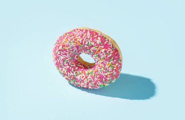 Delicious donut with sprinkles on blue background