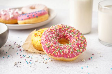 Parchment with delicious donuts on white table, closeup
