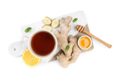 Board with ginger root, cup of black tea, honey and lemon isolated on white background