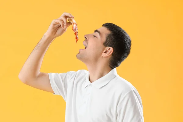 Young Man Eating Tasty Pizza Yellow Background — Stock Photo, Image