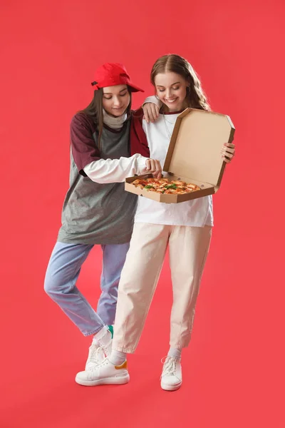 Giovani Donne Con Scatola Gustosa Pizza Sfondo Rosso — Foto Stock