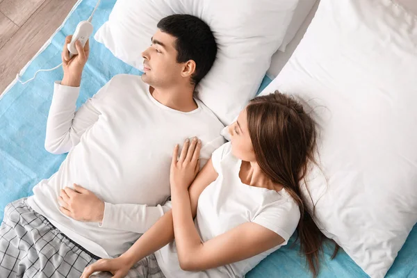 Young Couple Lying Electric Heating Pad Bedroom Top View — Stock Photo, Image