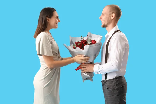 Young Man Greeting His Wife Bouquet Flowers Blue Background Valentine — Stock Photo, Image