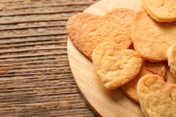 Board with sweet heart shaped cookies on wooden background. Valentines Day celebration