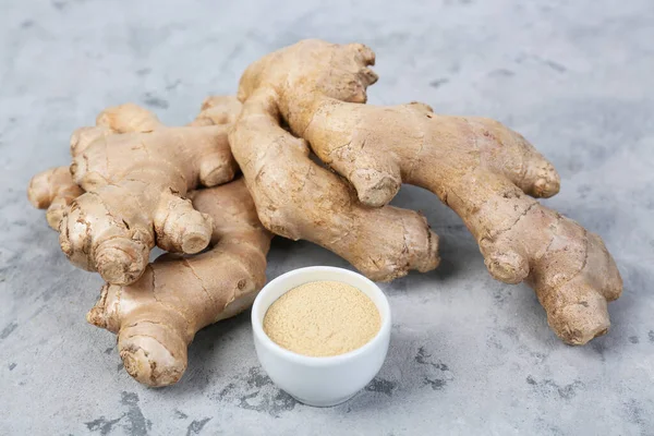 Powder and ginger roots on grunge background