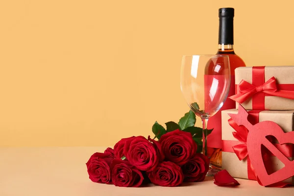 Rose flowers, bottle of wine, glass and gifts on beige background. Valentine\'s Day celebration