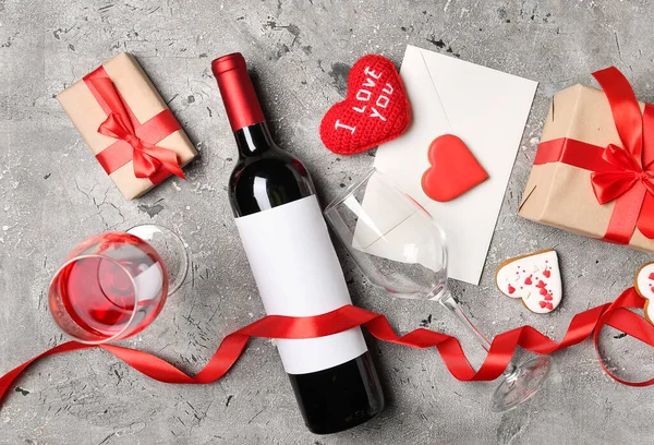 Bottle of wine, envelope, gift boxes and heart with text I LOVE YOU on grey table. Valentine\'s Day celebration