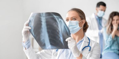 Klinikteki akciğerlerinin röntgen görüntüsüne sahip kadın doktor.