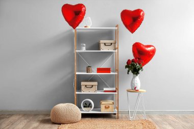 Interior of living room with shelving unit, balloons and engagement ring for Valentine's Day