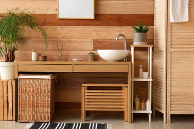 Interior of bathroom with sink, table and houseplants