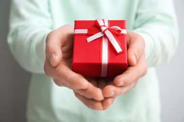 Man with gift box for Valentine's Day on grey background, closeup