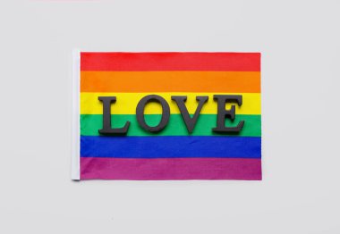 LGBT flag with word LOVE on grey background. Valentine's Day celebration