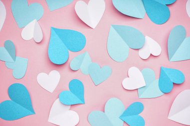 Composition with blue and white paper hearts on pink background. Valentines Day celebration