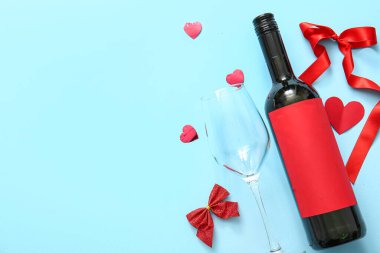 Composition with bottle of wine, glass and decor on color background. Valentines Day celebration