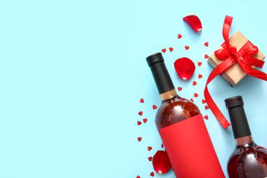 Composition with bottles of wine, gift box and rose petals on color background. Valentines Day celebration