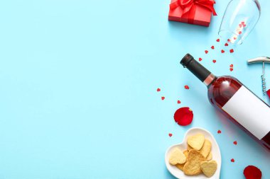 Composition with bottle of wine, glass and cookies on color background. Valentines Day celebration