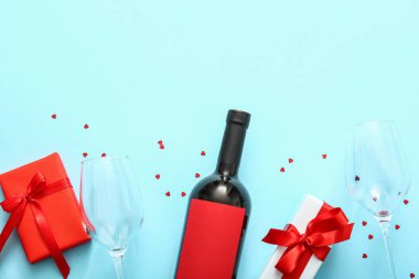 Composition with bottle of wine, glasses and gifts on color background. Valentines Day celebration