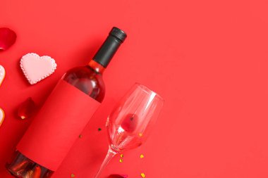 Composition with bottle of wine, glass and cookie on red background. Valentines Day celebration