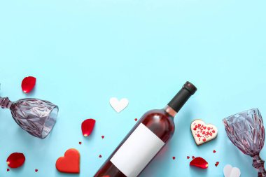 Composition with bottle of wine, glasses and cookies on color background. Valentines Day celebration