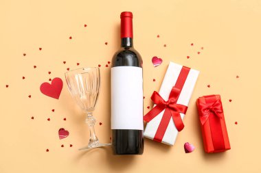 Composition with bottle of wine, glass and gifts for Valentines Day on color background