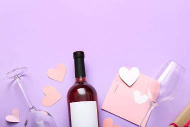 Composition with bottle of wine, glasses, envelope and paper hearts on lilac background. Valentines Day celebration