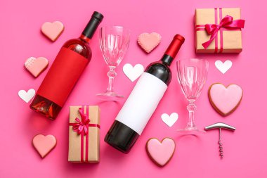 Composition with bottles of wine, glasses, cookies and gifts for Valentines Day on pink background