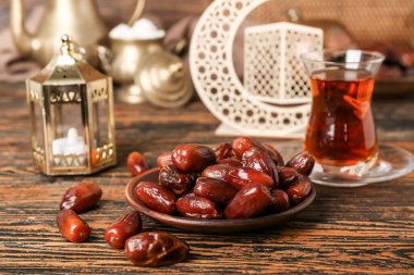 Plate with dried dates for Ramadan on wooden table, closeup