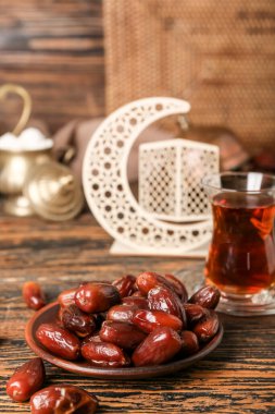 Plate with dried dates for Ramadan on wooden table, closeup