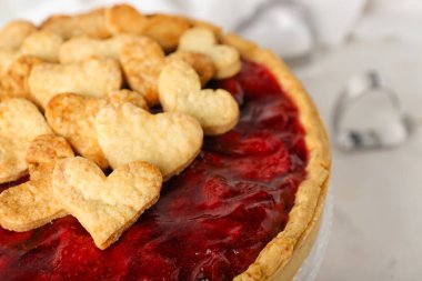 Sweet strawberry pie with cookie hearts for Valentine's day on light background