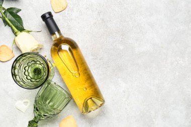 Bottle of wine, glasses, rose flower and hearts on grey table. Valentine's Day celebration