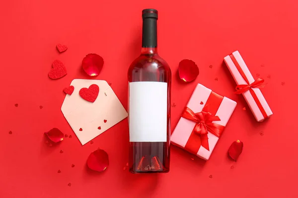 Σύνθεση Μπουκάλι Κρασί Δώρα Φάκελο Και Ροδοπέταλα Κόκκινο Φόντο Γιορτή — Φωτογραφία Αρχείου