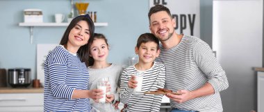 Happy family drinking milk during breakfast at home