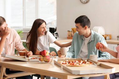Group of friends spending time together at table in kitchen
