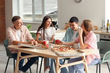 Group of friends spending time together at table in kitchen