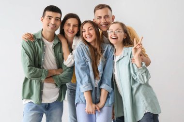 Group of happy friends on light background