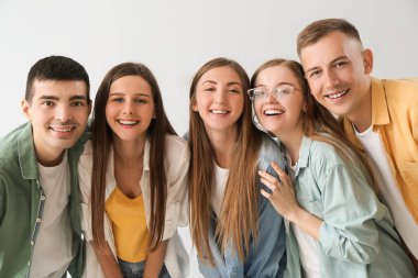 Group of happy friends on light background