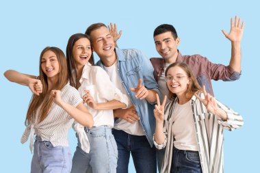 Group of happy friends dancing on blue background