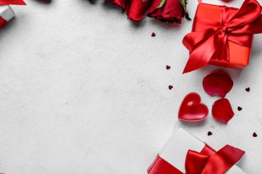 Composition with gift boxes and candle on light background, closeup. Valentine's Day celebration