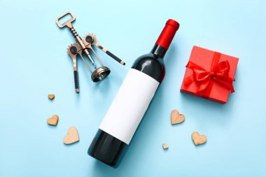 Composition with bottle of wine, corkscrew and gift box on color background. Valentines Day celebration