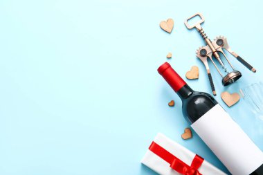 Composition with bottle of wine, corkscrew, gift box and decor on color background. Valentines Day celebration