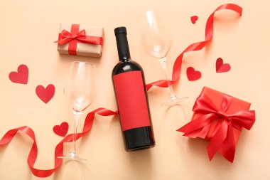 Composition with bottle of wine, gifts, glasses and decor on color background. Valentines Day celebration