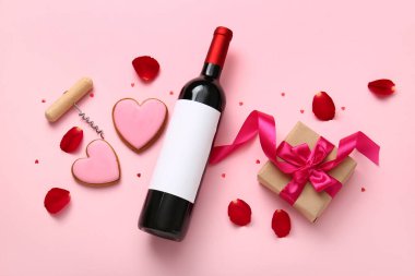 Composition with bottle of wine, cookies and gift for Valentines Day on pink background