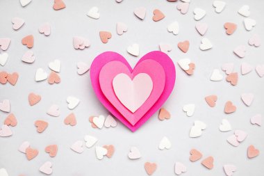 Composition with paper hearts and colorful sprinkles on light background. Valentines Day celebration