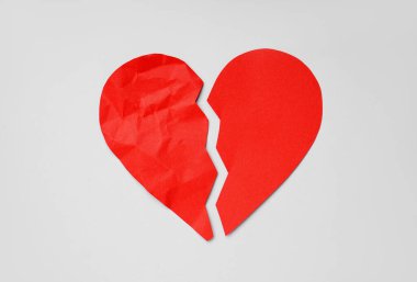 Broken red paper heart on light background. Valentines Day celebration